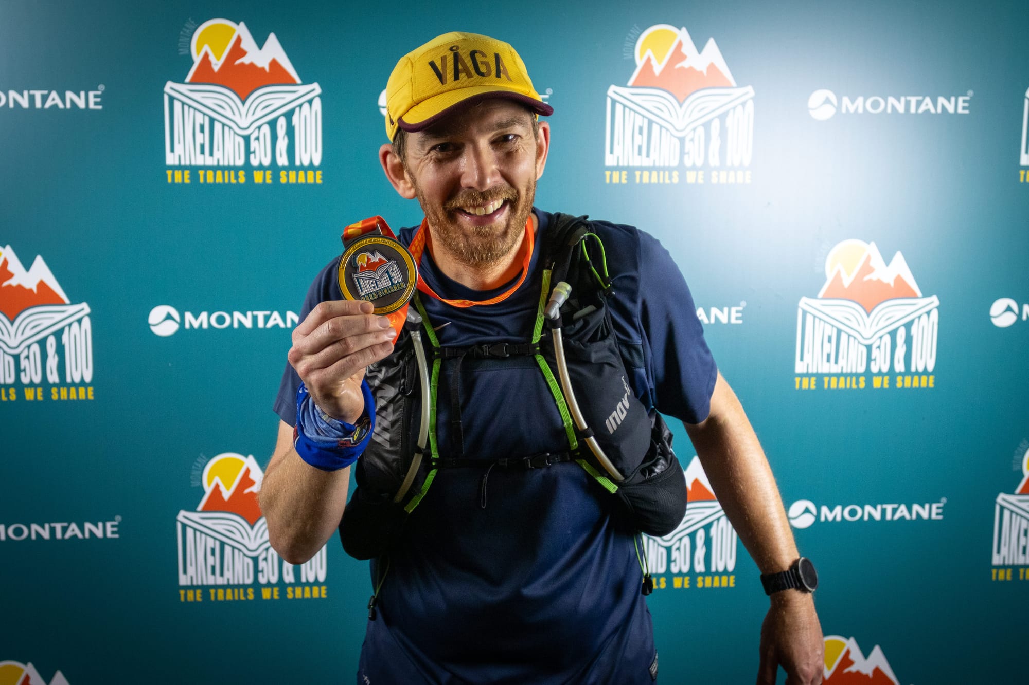 Jon Hickman (me) smiling and holding a Lakeland 50 medal, 1am-ish on 27th July 2025
